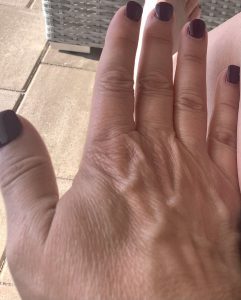 a woman's hand with plum nailpolish