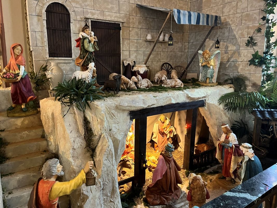 Nativity scene with figurines and stable, festive Christmas display.
